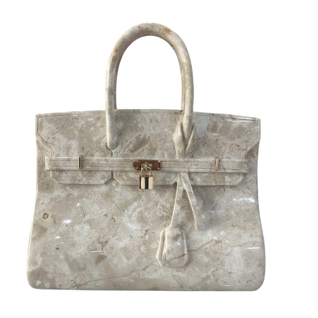 Hand-carved marble handbag sculpture by Fringe the Artist